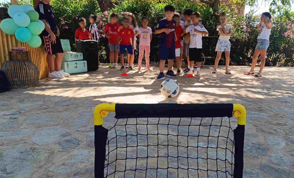 Niños jugando al fútbol con una mini porteria en una animación infantil durante un cumpleaños.