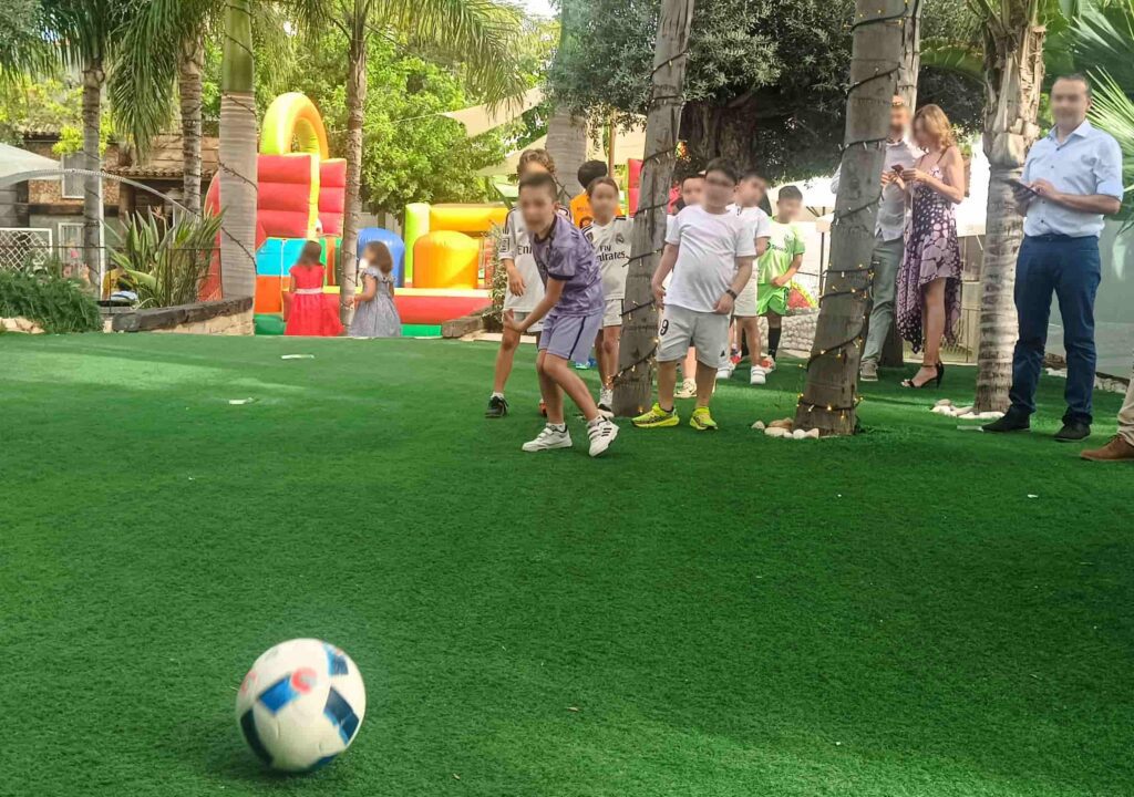 Niños haciendo un reto de fútbol freestyle durante una comunión en Valencia